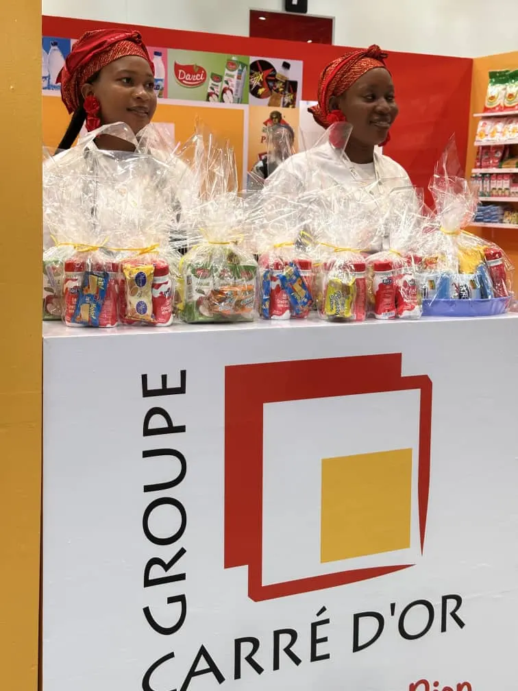 Stand du Groupe Carré d’Or : hôtesses et coffrets de produits emballés sous le logo du groupe